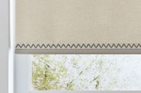 beige roller blind with dark braided trim at the edge
