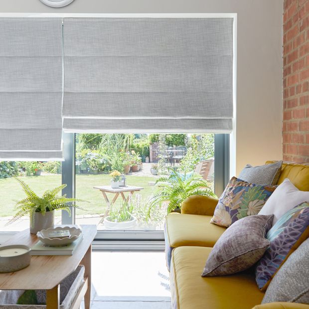 pair of silver roman blinds on large sliding patio doors in living room