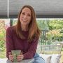bea taylor sat in kitchen with duette charcoal pleated blinds on patio doors behind her