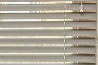 close up of grey metal venetian blinds on kitchen window