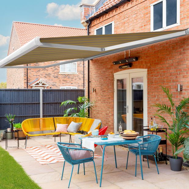 striped yellow  motorised awning in modern garden