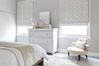 Cream Blackout blinds covering bright bedroom windows