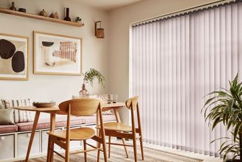 Brown vertical blinds shading tall dining room windows