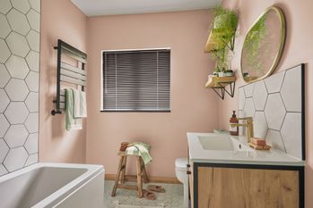 Black metal venetian blind in light pink bathroom
