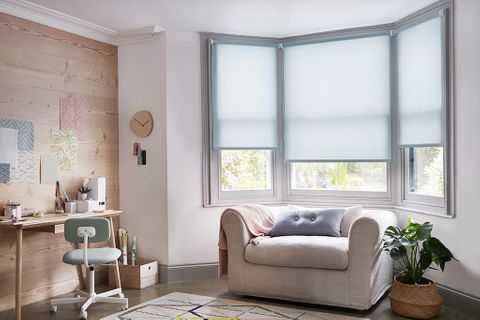 Scandi design home office with a light blue roller blind hung in the window