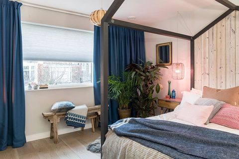 Scandi luxe bedroom decorated with blue pleated blinds and paired with blue curtains