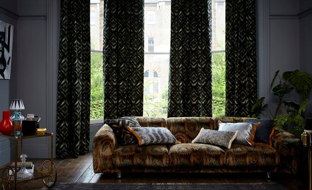 Harkness Gasoline Curtains fitted to a bay window in a grey decorated living room with wooden floors