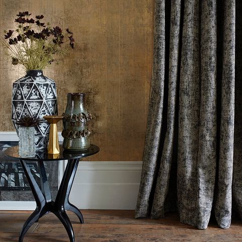 Living room with coffee table that has a large vase on it and Garcia Phantom Curtains to the right