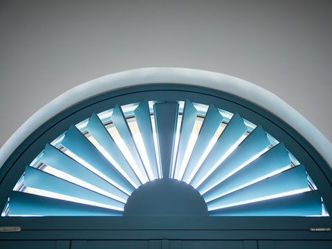 Closeup of blue custom colour shaped shutters in hallway 