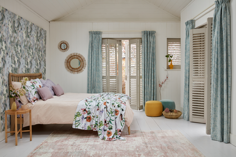 Guest bedroom garden room with full height tracked shutters and full length curtains