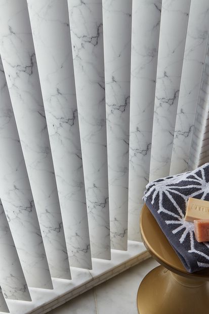 marble patterned vertical blinds fitted in a bathroom with marble flooring, hand towel and soaps