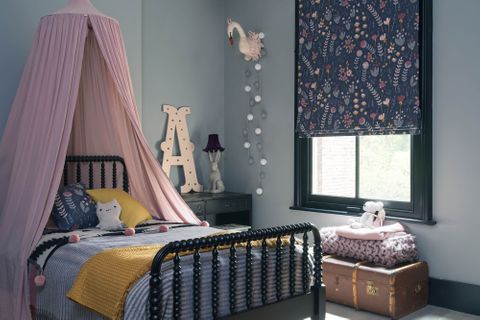 Blue floral roman blinds and matching cushion on bed in children bedroom 