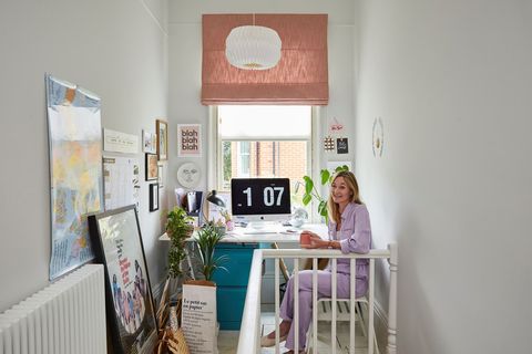 A lady sitting at a desk at the end of a landing
