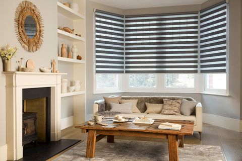 A close up of a golden coloured living room with taupe Day and Night roller blinds