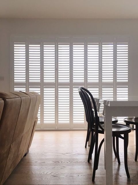 white tracked shutters in dining room