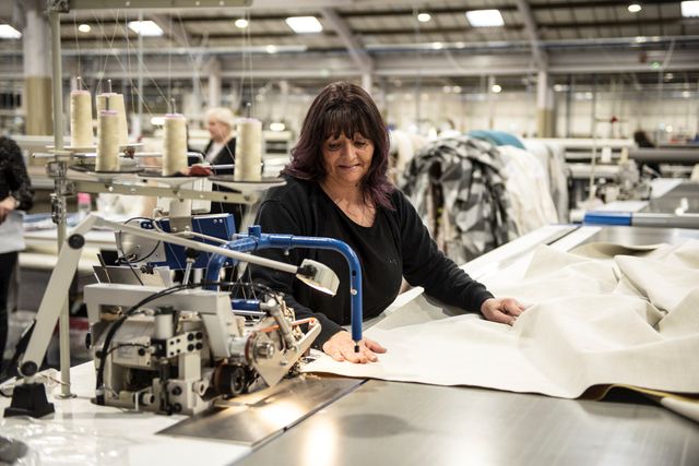 Behind the scenes in the factory with lady sewing curtain lining