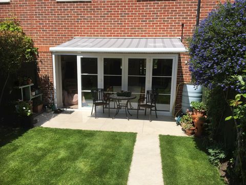 Grey Awning installation above back garden patio doors