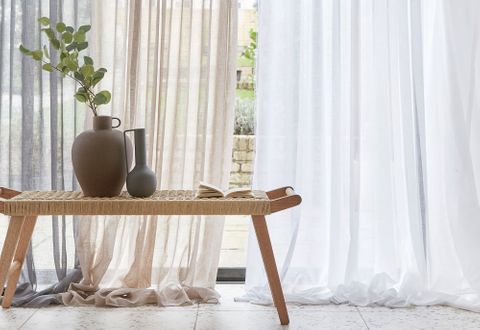 Close up shot of Serenity White, Serenity Linen and Serenity Silver voile curtains against large wide window leading to garden