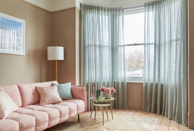 Serenity seaglass voile curtains in 3-sided sash bay window with light pink sofa and pastel accessories