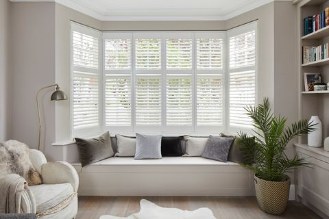 Richmond Silkwhite Shutters in a lounge window with white furniture 