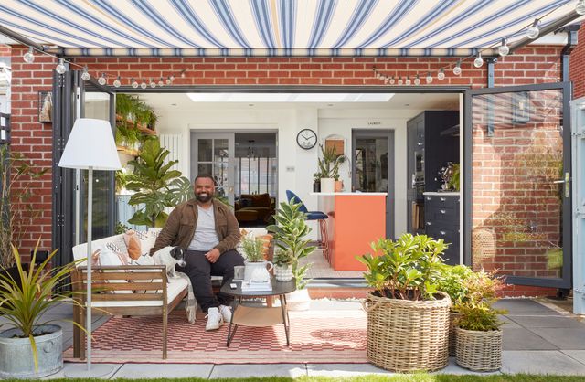 Man sat in lavish outdoor patio area with Rome blue awnings fully outstretched above