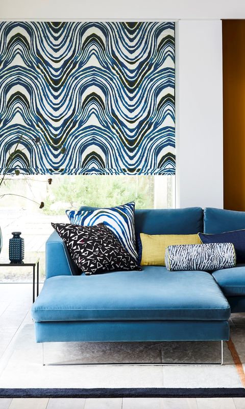 Kovu mirage Roman blinds in a living room with a sofa