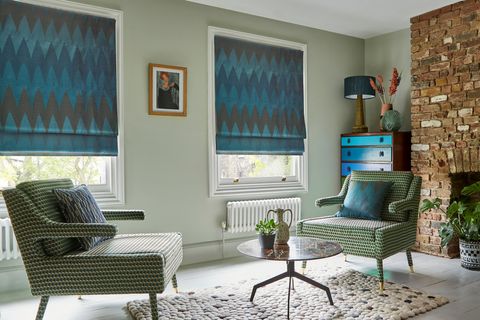 Zaha Deep Teal Roman blind on two windows in a lounge with two armchairs and a coffee table