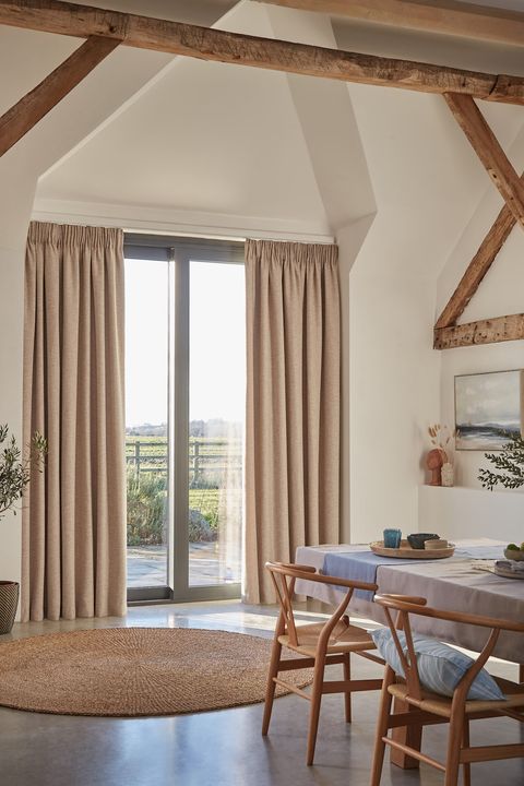 Nest Almond curtain opened in a lounge window