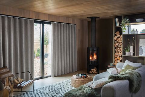 Nest Pewter curtains in a lounge window next to the fire place