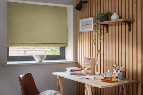 Serene Wasabi roman blinds in a small office room with a desk and a chair and office stationary on the desk