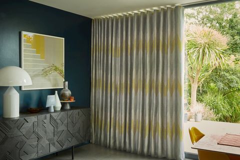 Zaha Sunrise Curtains fitted to a tall door window in a dining room with blue coloured walls