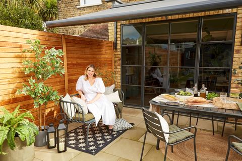 Sally Cullen sat on a chair in her garden under an awning