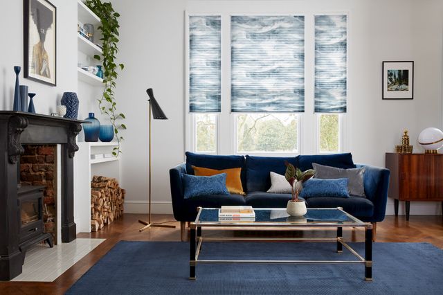 House Beautiful Ripple Blue Pleated blinds in a living room with a navy sofa