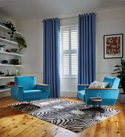 Faso cornflower blue eyelet curtains paired with white shutters in living room