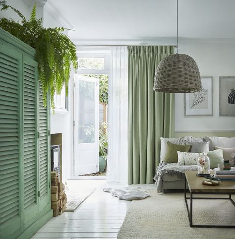 Pearl olive green floor length pinch pleat curtains paired with voiles in cosy living room