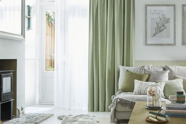 Pearl olive green floor length pinch pleat curtains paired with voiles in cosy living room