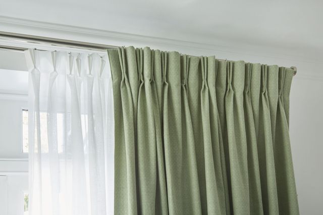 Pearl olive green floor length pinch pleat curtains paired with voiles in cosy living room