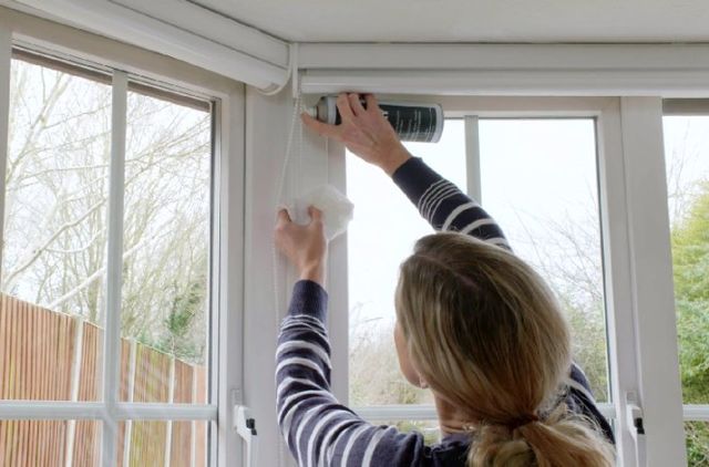 woman cleaning day and night blinds