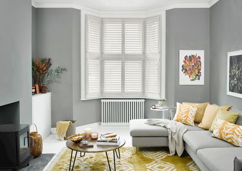 matte white tier on tier shutters on bay window in living room