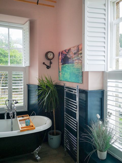 Set of tier on tier shutters on bathroom windows with greenery surrounding them