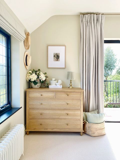 cream striped curtains paired with plain ivory roman blinds in beige themed bedroom