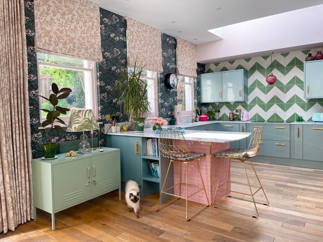 pink floral roman blind and curtain in kitchen/living area with floral patterned walls and furnishings