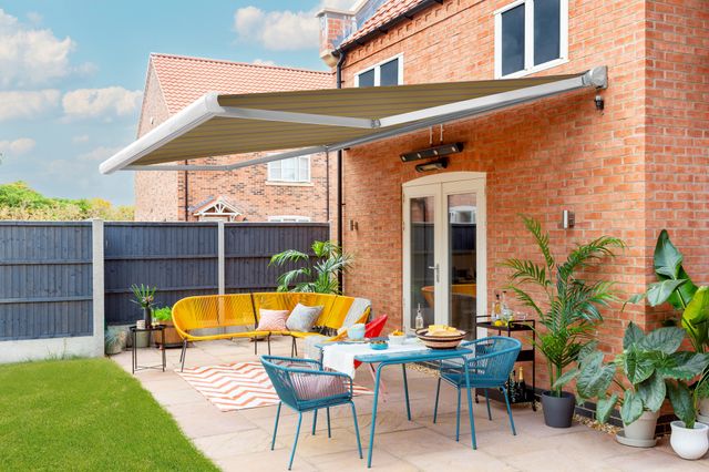 striped yellow  motorised awning in modern garden